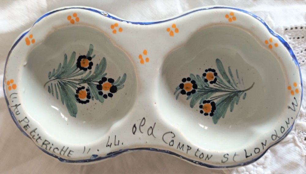 A double salt cellar made of pale blue tin-glazed ceramic with hand-painted floral motifs in blue, green, and orange. View II