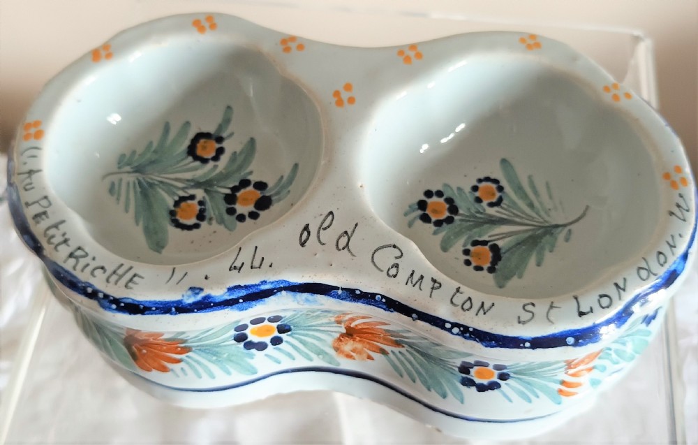 A double salt cellar made of pale blue tin-glazed ceramic with hand-painted floral motifs in blue, green, and orange. View IV