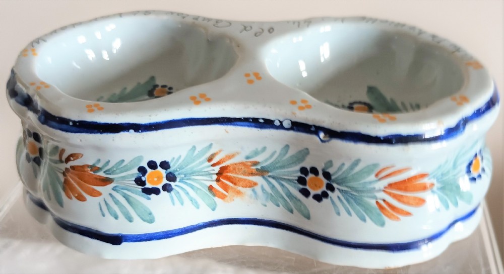 A double salt cellar made of pale blue tin-glazed ceramic with hand-painted floral motifs in blue, green, and orange. View VI