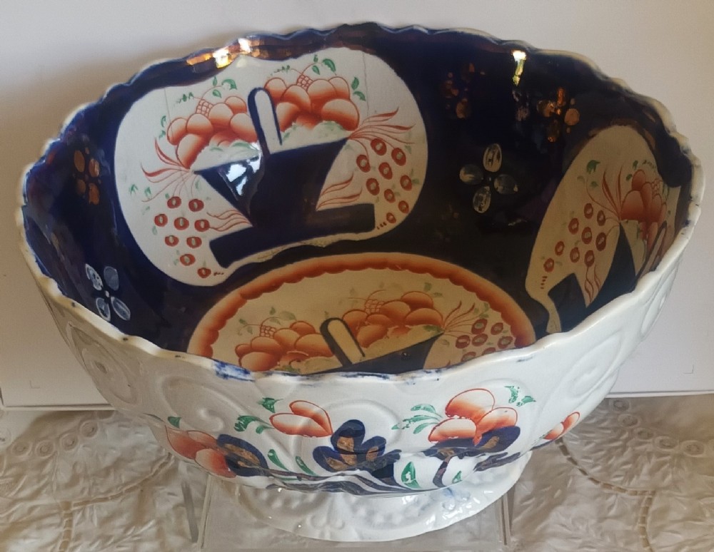 An antique Victorian Gaudy Welsh footed earthenware bowl decorated with cobalt blue, rust-orange basket of flowers motifs, and copper lustre details.