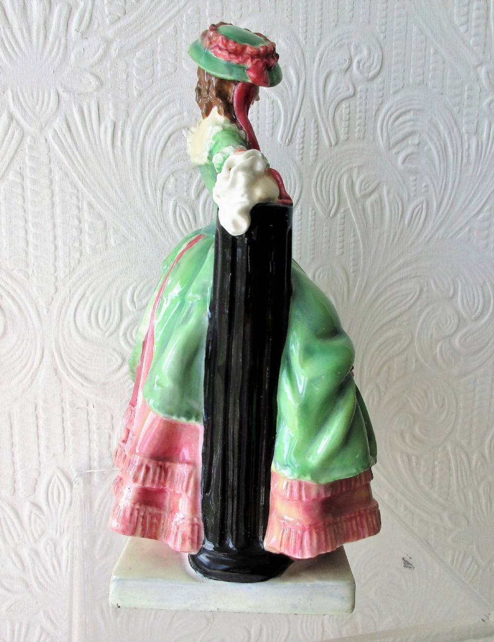 A vintage Royal Doulton porcelain figurine titled Kate Hardcastle depicting a woman in an 18th-century style green overskirt and pink ruffled dress. View IV