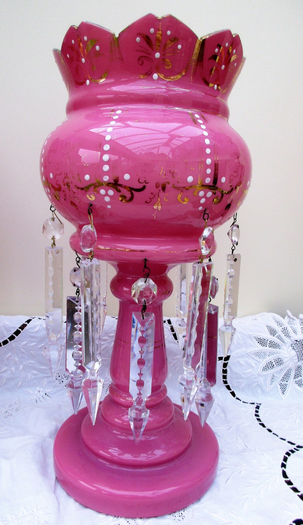 A pair of Victorian pink glass lustres decorated with gilded scrolling, enamel dots, scalloped rims, and suspended clear cut-glass prisms. View III