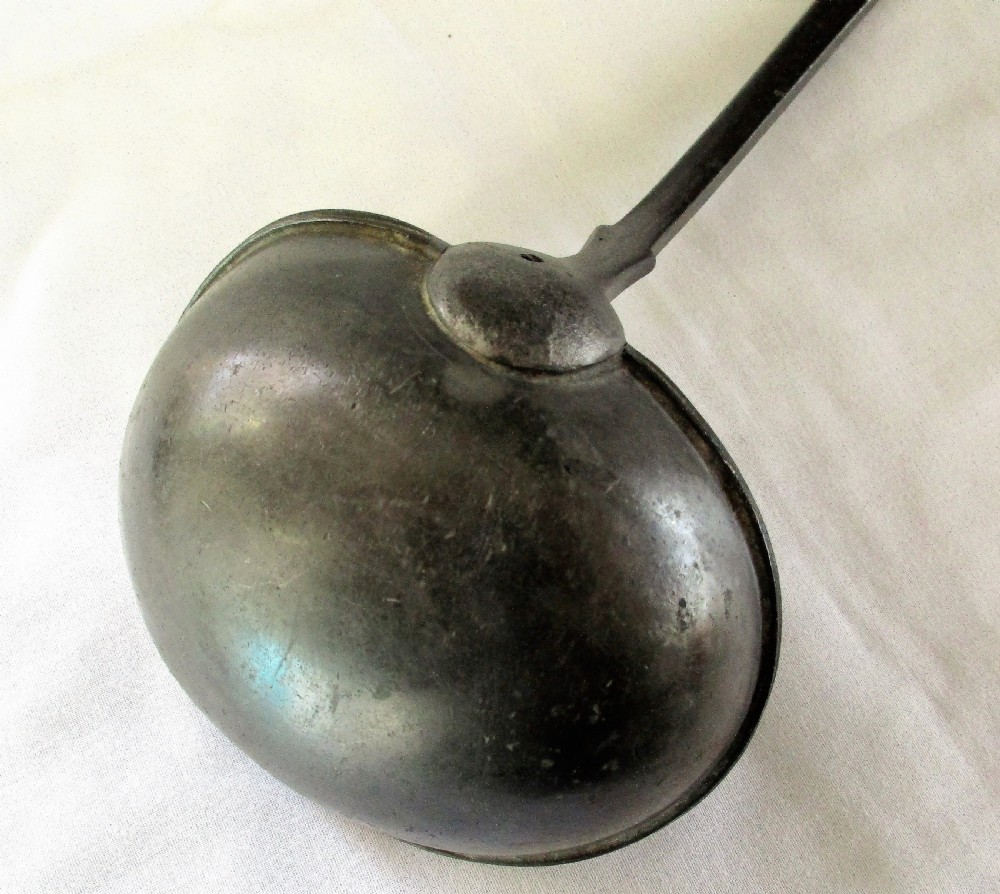 An antique Georgian pewter ladle featuring a rounded deep bowl and a long flattened handle stem. View IV
