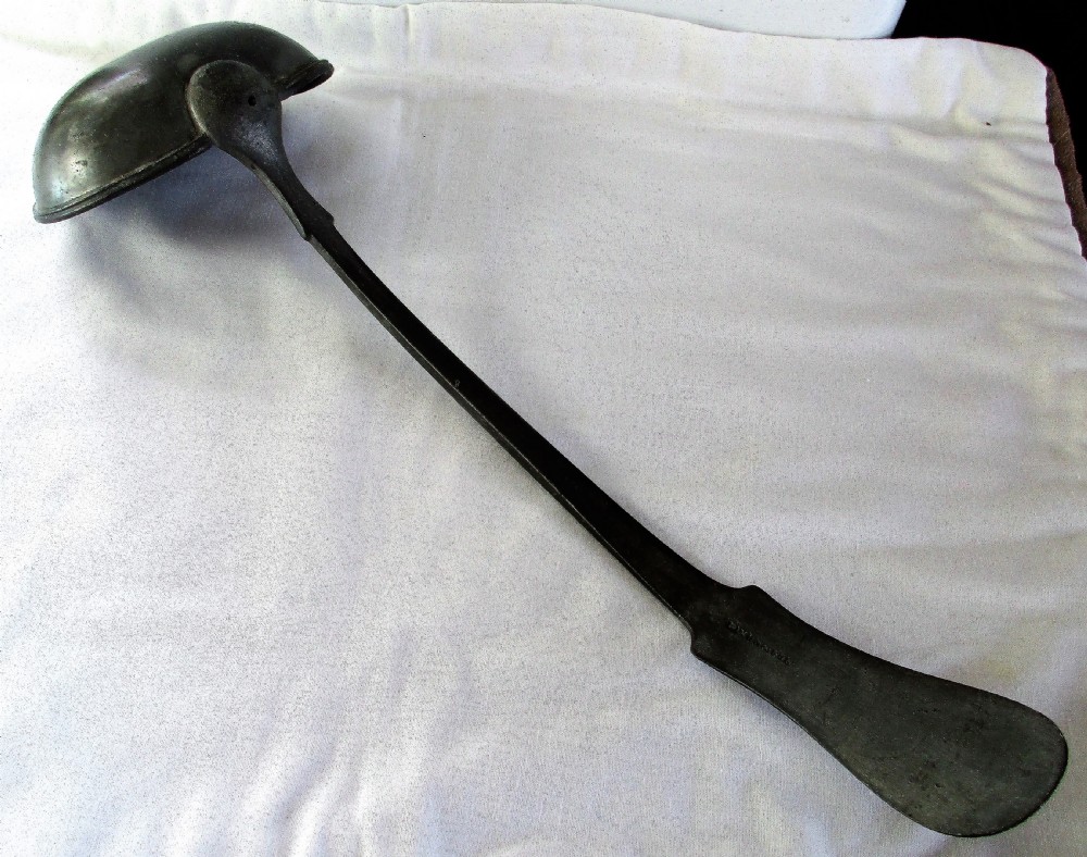 An antique Georgian pewter ladle featuring a rounded deep bowl and a long flattened handle stem. View VI
