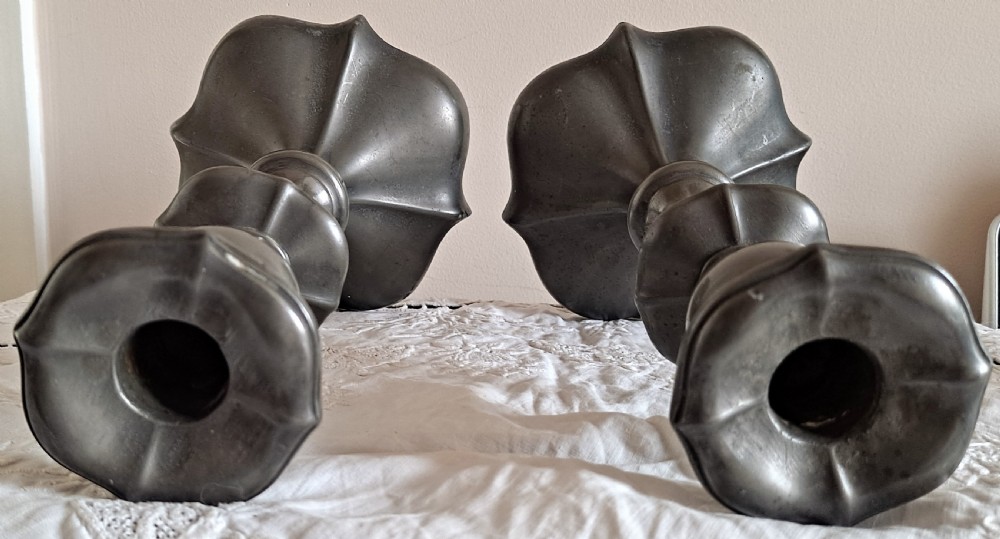 A pair of dark pewter candlesticks featuring sinuous baluster stems and flared lobed bases. View VI