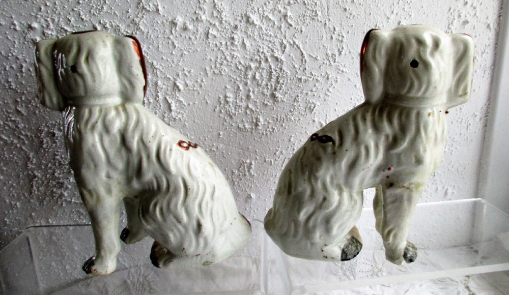 A pair of seated antique Victorian Staffordshire pottery spaniel dog figurines with white glazed bodies and painted copper lustre spots. View III