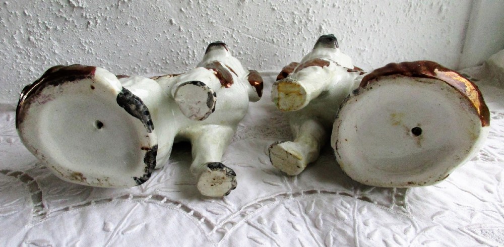 A pair of seated antique Victorian Staffordshire pottery spaniel dog figurines with white glazed bodies and painted copper lustre spots. View VI