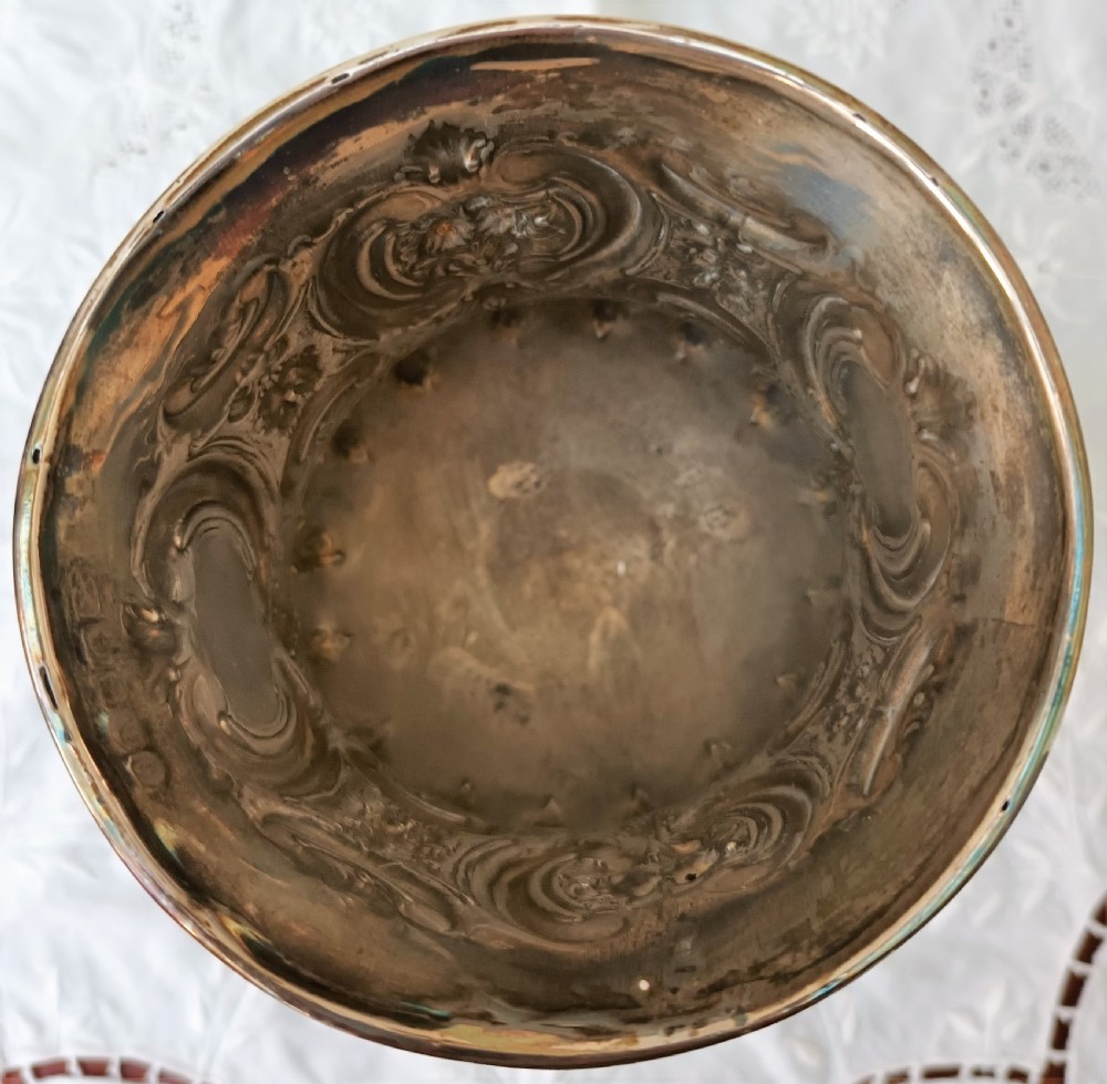 An antique Victorian sterling silver chalice featuring intricate repousse scrollwork, embossed decoration, and official Sheffield hallmarks near the rim. View VI