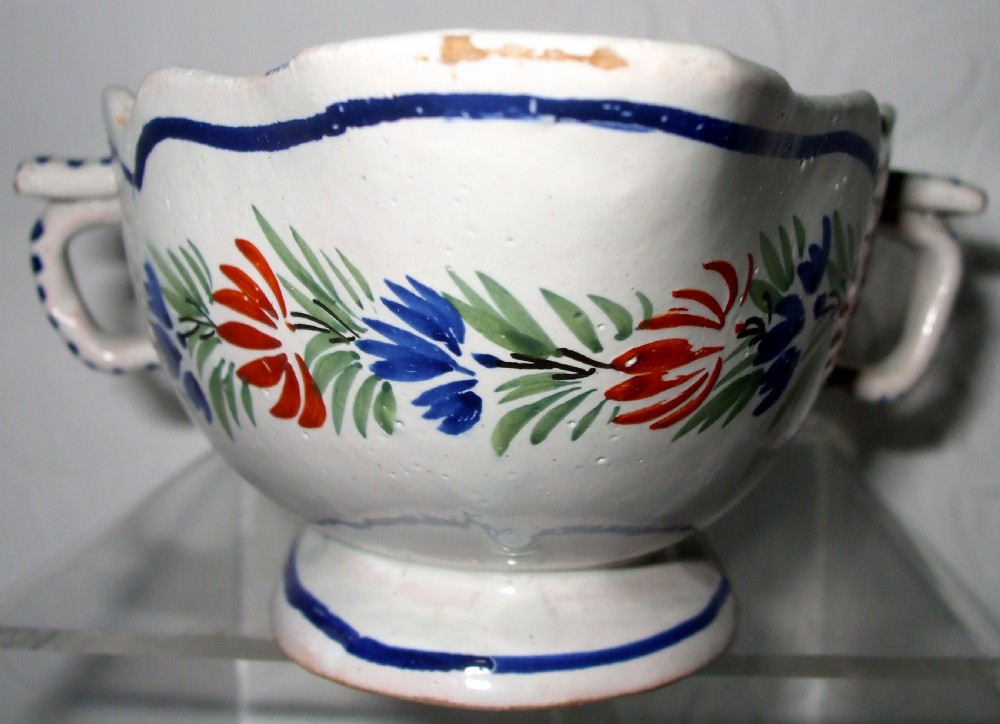 A double-lipped French faience sauceboat featuring hand-painted floral decoration and striped side handles against a white glazed background. View IV