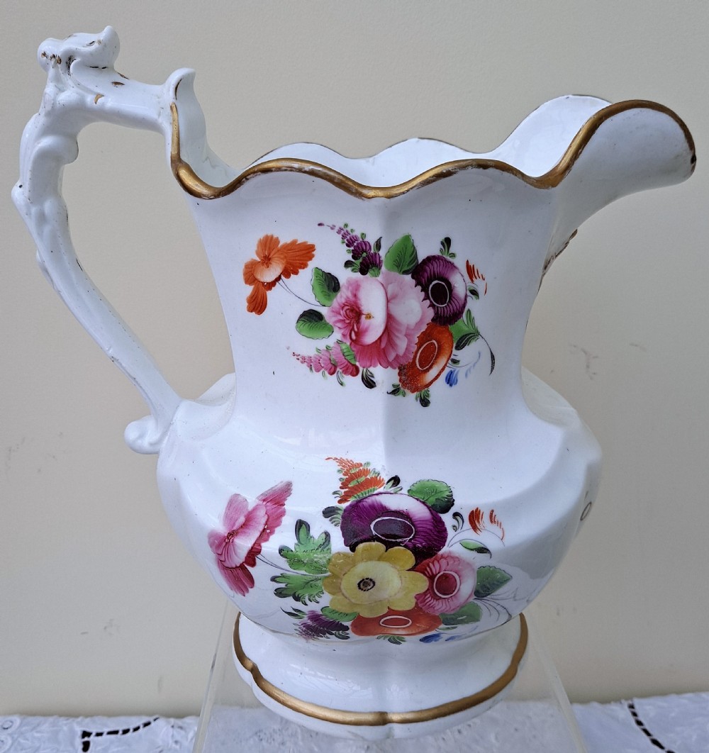 A white early Victorian porcelain jug decorated with hand-painted floral sprays and a gilded rim and handle. View III