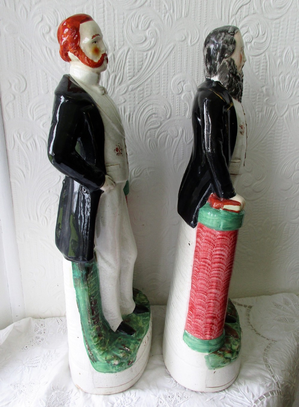 A pair of antique Victorian Staffordshire earthenware portrait figures depicting Moody and Sankey standing beside red pillars with moulded bases. View IV