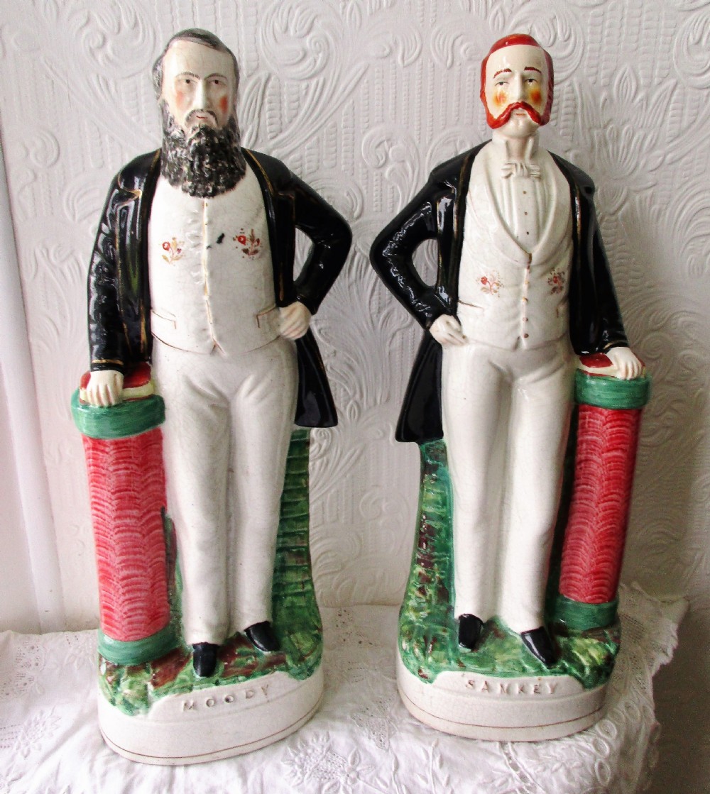 A pair of antique Victorian Staffordshire earthenware portrait figures depicting Moody and Sankey standing beside red pillars with moulded bases. View V