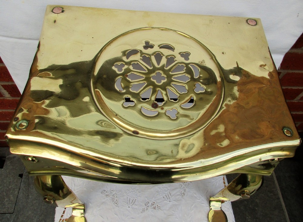 A Victorian polished brass and steel fireplace footman featuring a pierced floral apron and cabriole front legs. View II