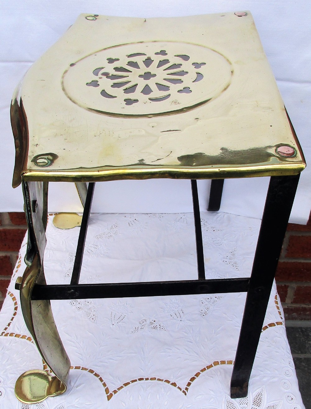 A Victorian polished brass and steel fireplace footman featuring a pierced floral apron and cabriole front legs. View III