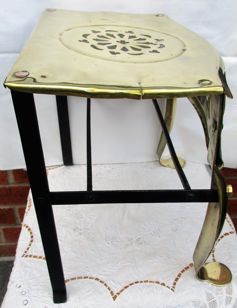 A Victorian polished brass and steel fireplace footman featuring a pierced floral apron and cabriole front legs. View IV