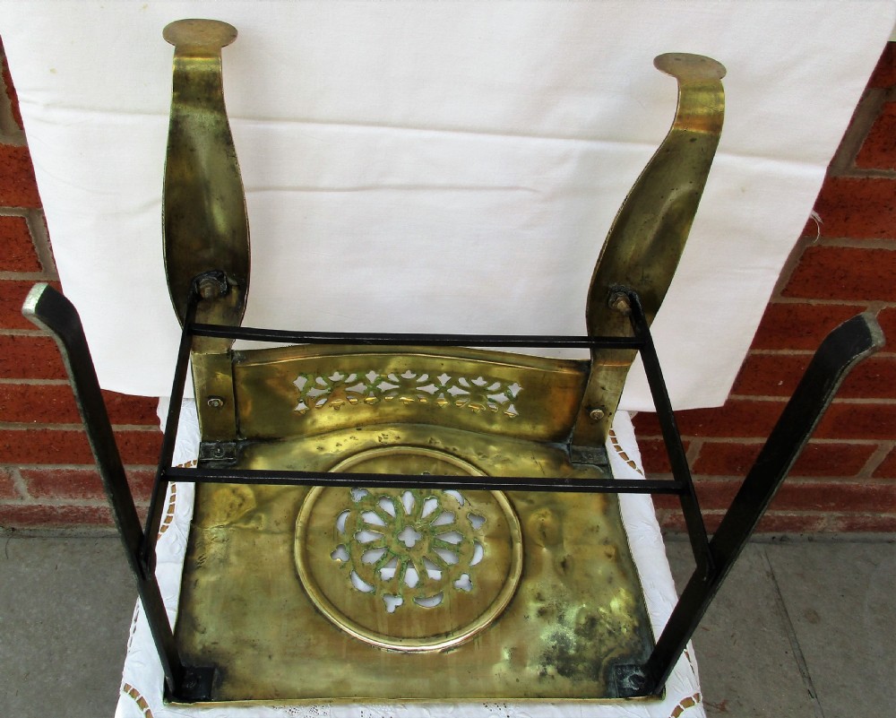 A Victorian polished brass and steel fireplace footman featuring a pierced floral apron and cabriole front legs. View V