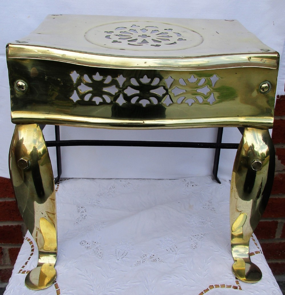 A Victorian polished brass and steel fireplace footman featuring a pierced floral apron and cabriole front legs. View VI
