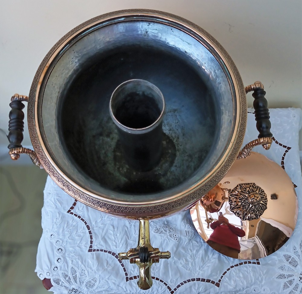 A polished Georgian copper tea urn featuring twin reeded handles, a brass spigot tap, and a square pedestal base resting on ball feet. View XIII
