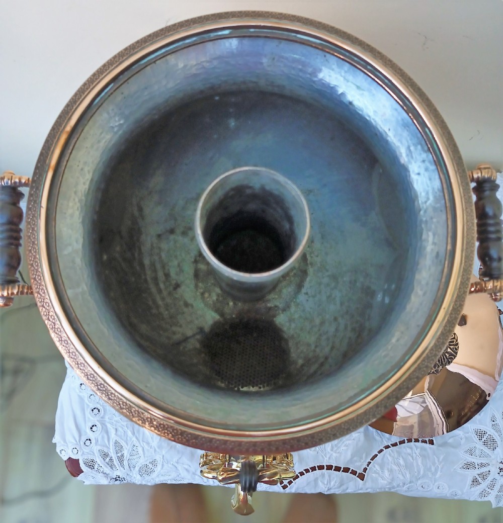 A polished Georgian copper tea urn featuring twin reeded handles, a brass spigot tap, and a square pedestal base resting on ball feet. View XIV