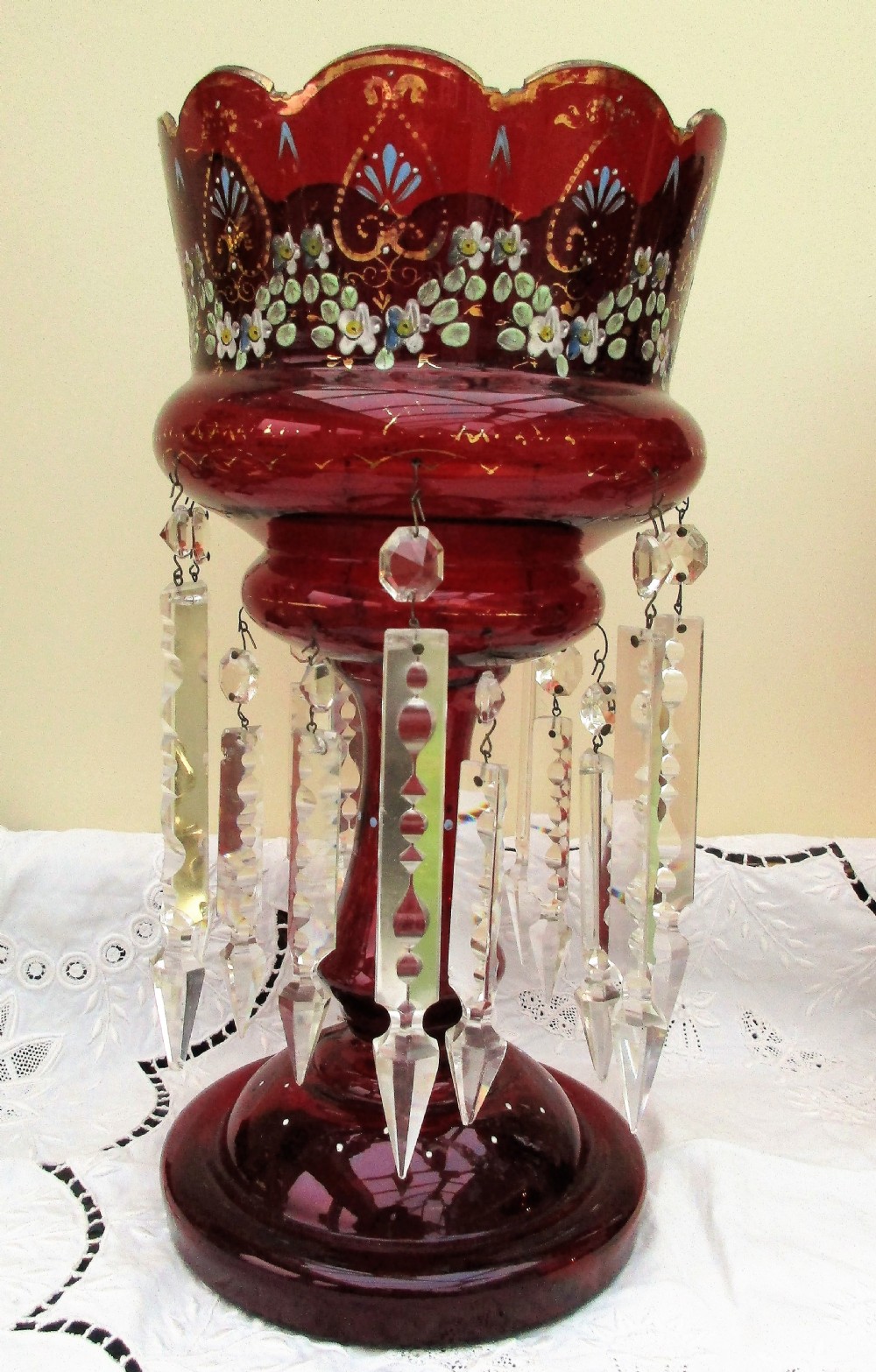 A pair of Victorian ruby red glass lustres featuring hand-painted floral enamel decoration and suspended clear cut-crystal prisms on circular bases. View II