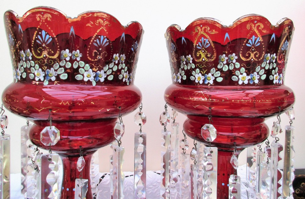 A pair of Victorian ruby red glass lustres featuring hand-painted floral enamel decoration and suspended clear cut-crystal prisms on circular bases. View IV