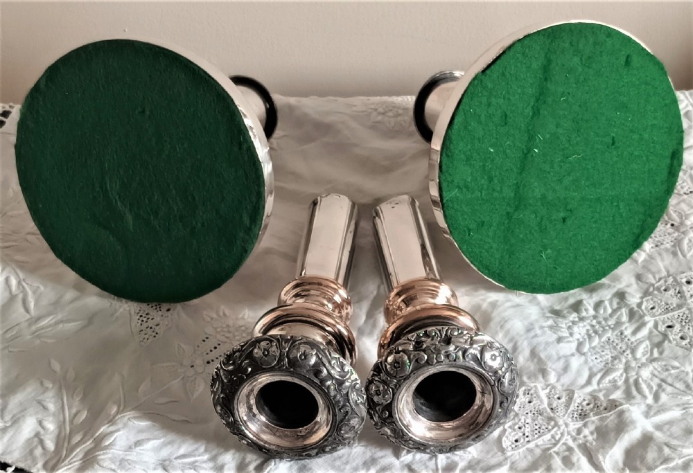 A pair of Georgian Old Sheffield Plate telescopic candlesticks featuring extendable silver columns showing copper undertones and ornate embossed borders. View III