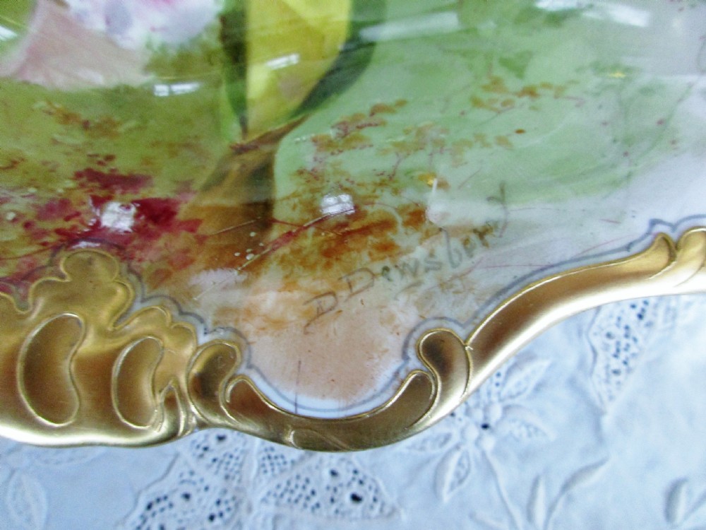 An oval antique porcelain dish featuring hand-painted pink orchids on a pale green ground with a gilded scrolled rim. View II