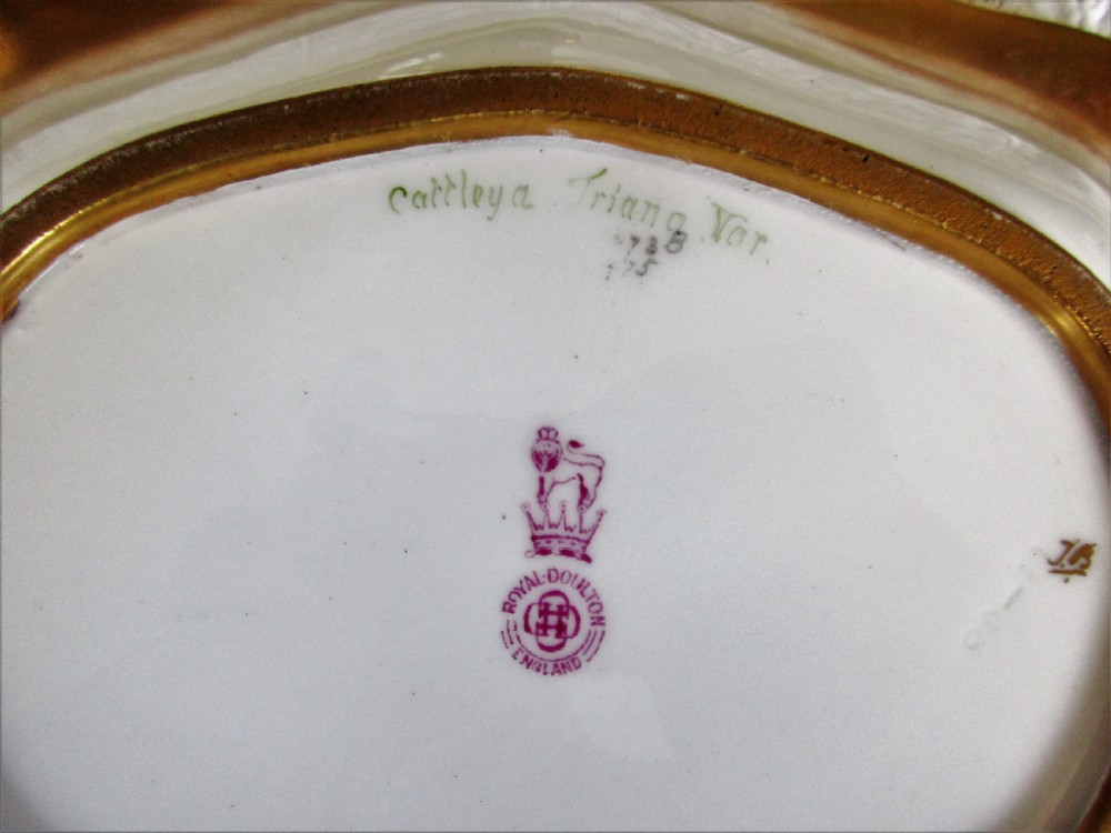 An oval antique porcelain dish featuring hand-painted pink orchids on a pale green ground with a gilded scrolled rim. View IV