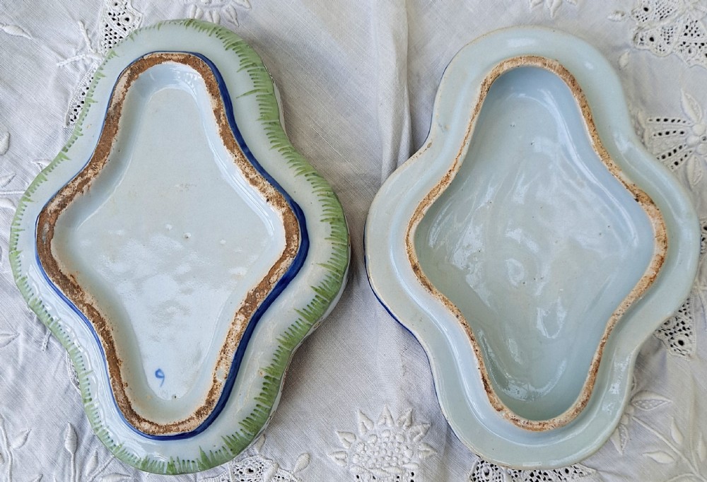 A shaped hand-painted French faience lidded trinket box with polychrome scroll and floral decoration on an off-white glaze. View VII