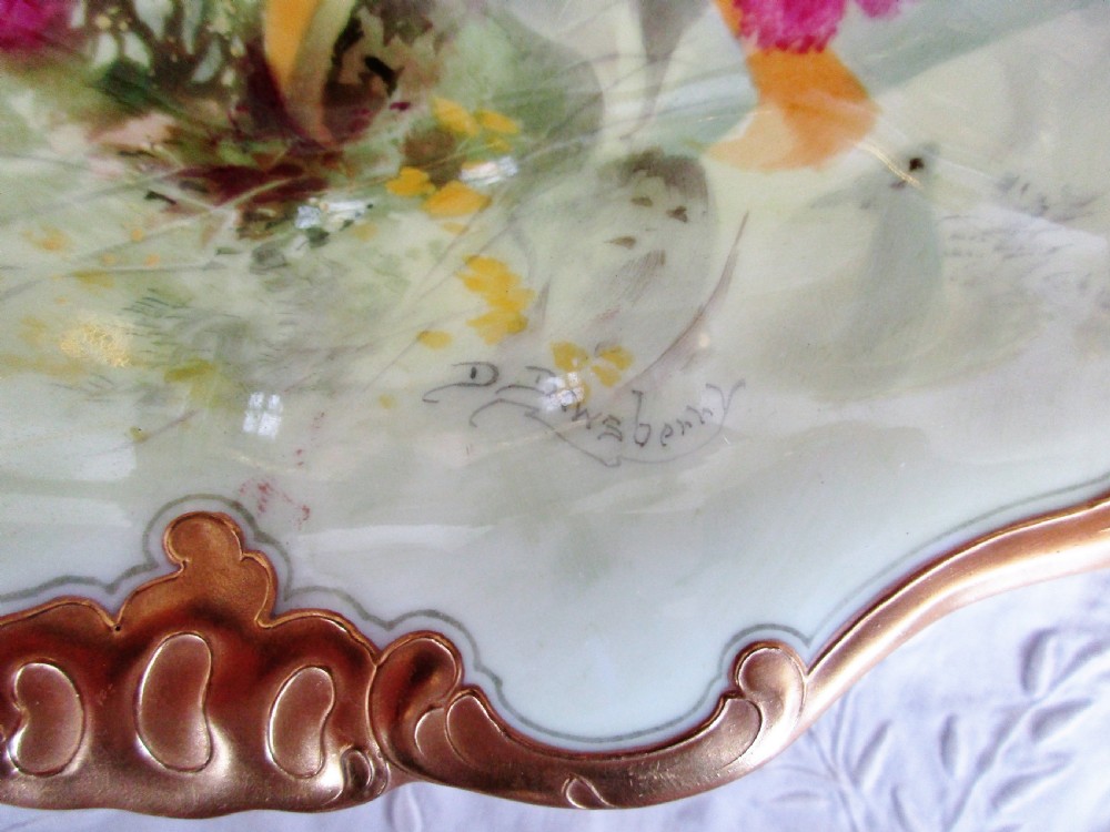 An oval antique porcelain cabinet dish featuring hand-painted yellow and pink orchids with elaborate gilded scrollwork borders. View II