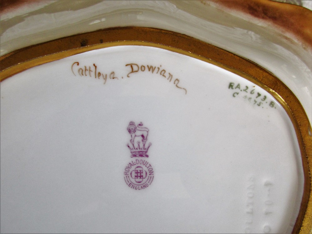 An oval antique porcelain cabinet dish featuring hand-painted yellow and pink orchids with elaborate gilded scrollwork borders. View IV