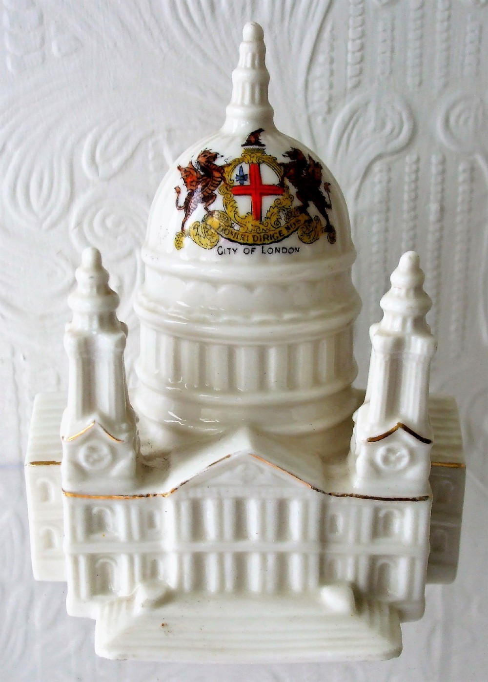 An antique off-white glazed porcelain model of St Pauls Cathedral featuring the coat of arms of the City of London on its central dome.