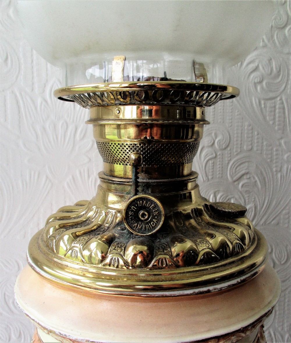 An antique Victorian porcelain oil lamp featuring a sculpted male figurine base, relief reservoir, brass burner, and a fluted green glass shade. View VIII