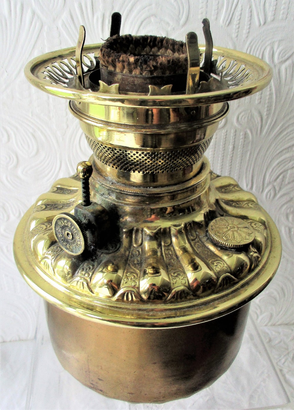 An antique Victorian porcelain oil lamp featuring a sculpted male figurine base, relief reservoir, brass burner, and a fluted green glass shade. View IX
