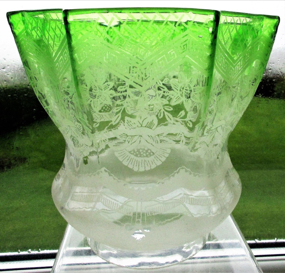 An antique Victorian porcelain oil lamp featuring a sculpted male figurine base, relief reservoir, brass burner, and a fluted green glass shade. View X
