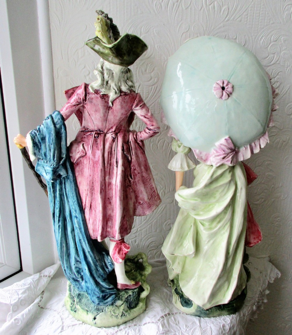 A pair of hand-painted French faience ceramic figurines depicting an 18th-century gentleman and a lady holding a parasol. View III