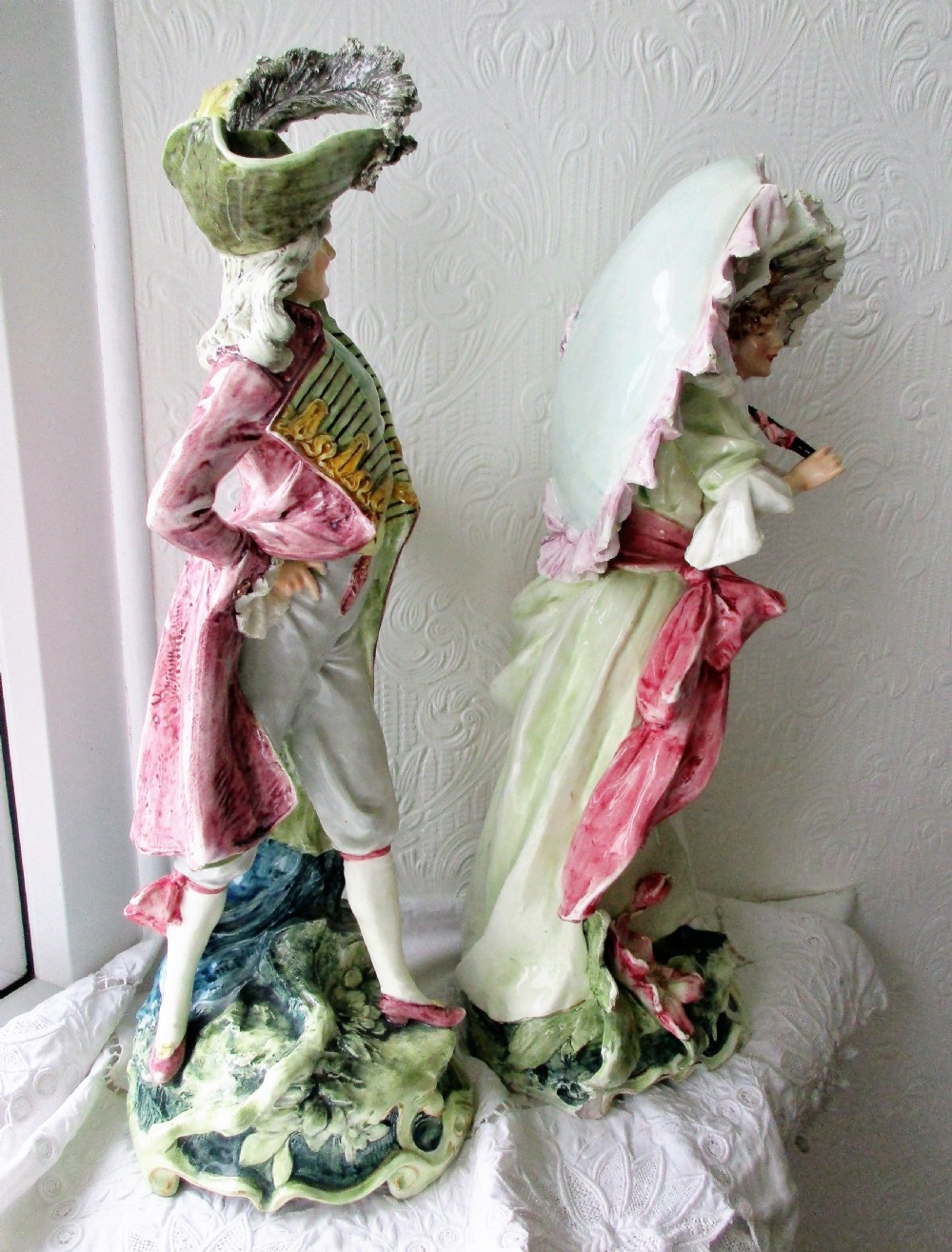 A pair of hand-painted French faience ceramic figurines depicting an 18th-century gentleman and a lady holding a parasol. View IV