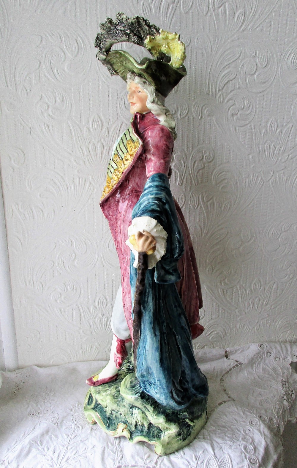 A pair of hand-painted French faience ceramic figurines depicting an 18th-century gentleman and a lady holding a parasol. View VI