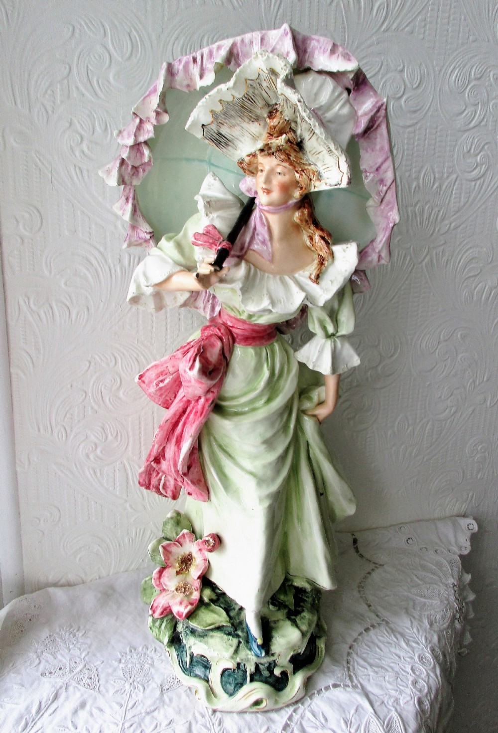 A pair of hand-painted French faience ceramic figurines depicting an 18th-century gentleman and a lady holding a parasol. View X