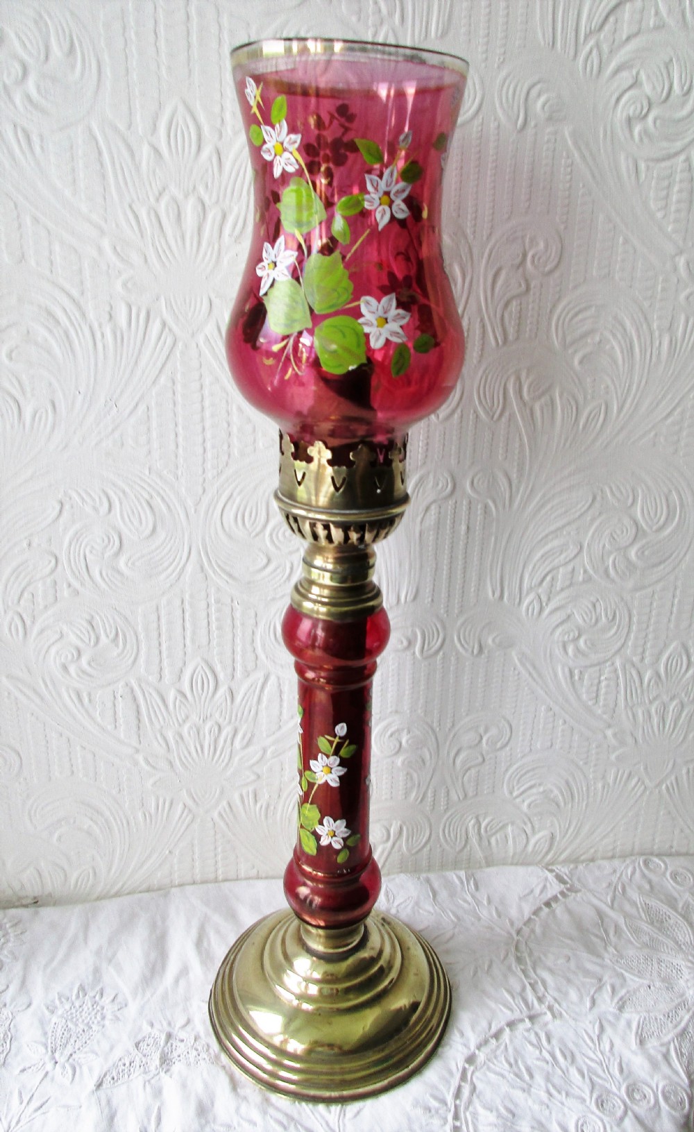 A pair of Victorian brass candle lamps featuring hand-painted floral enamel on red cranberry glass shades and stems. View III