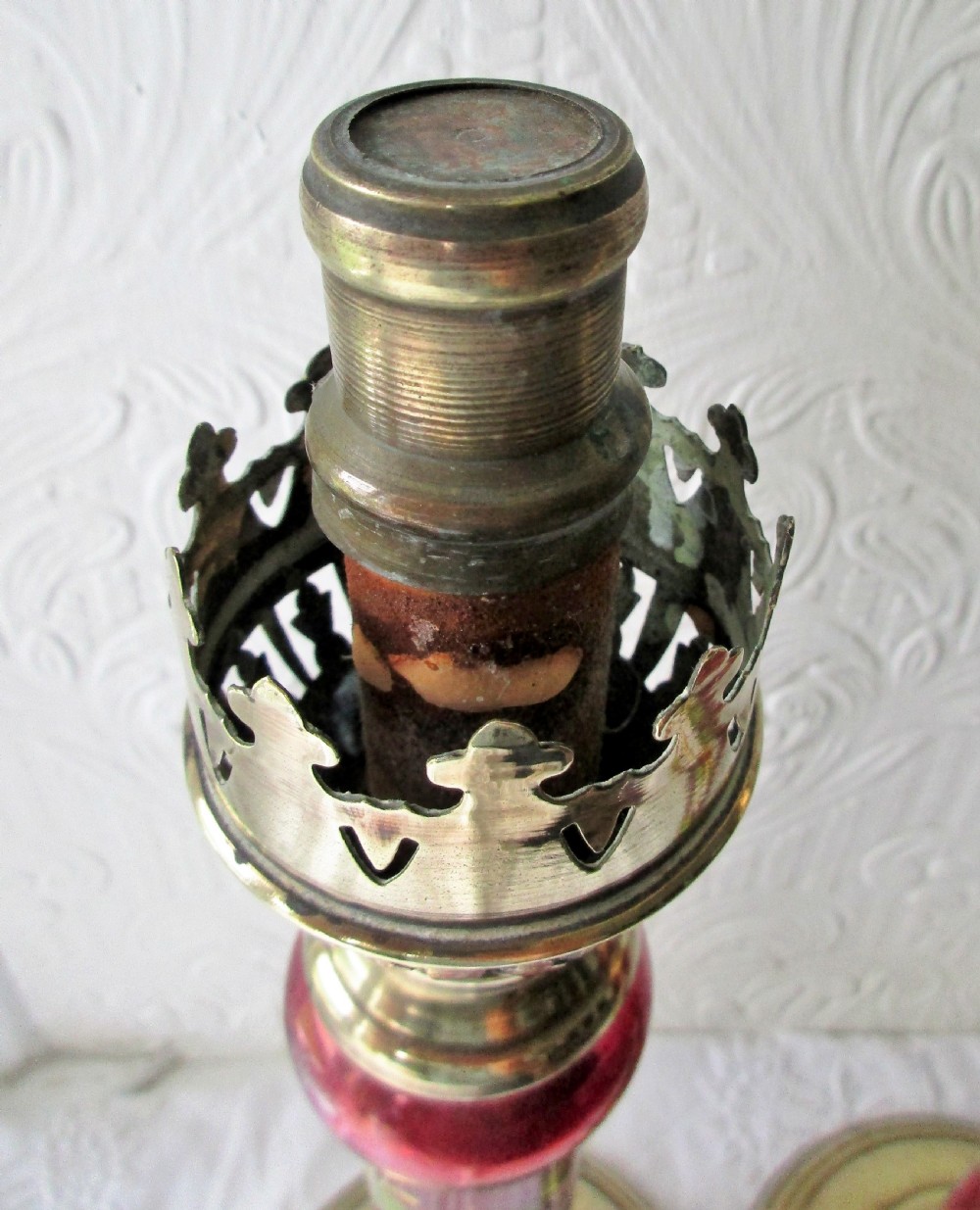 A pair of Victorian brass candle lamps featuring hand-painted floral enamel on red cranberry glass shades and stems. View IV
