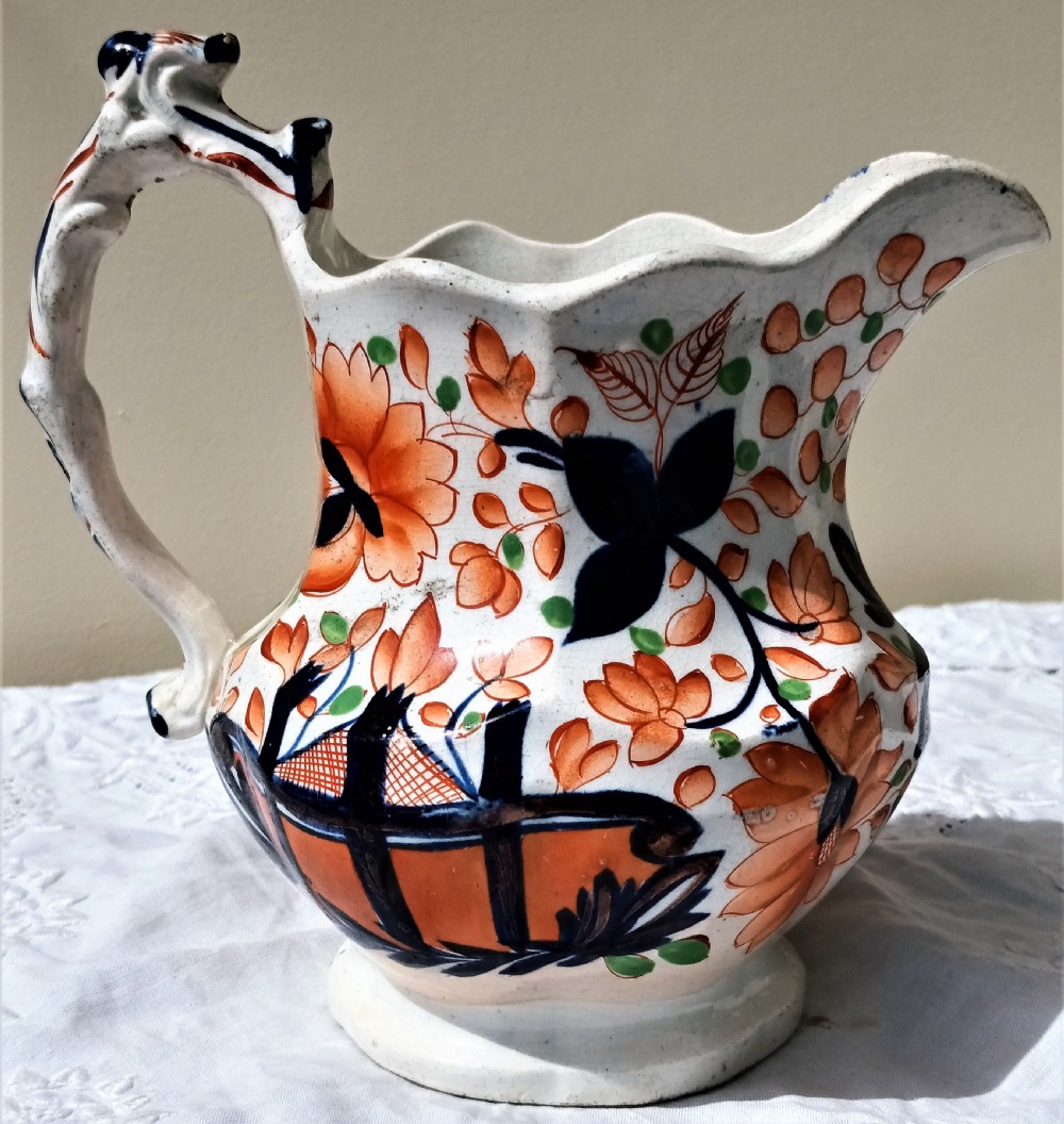 An antique Victorian Gaudy Welsh earthenware jug decorated with hand-painted orange floral motifs, cobalt blue details, a scalloped rim, and a molded handle. View III