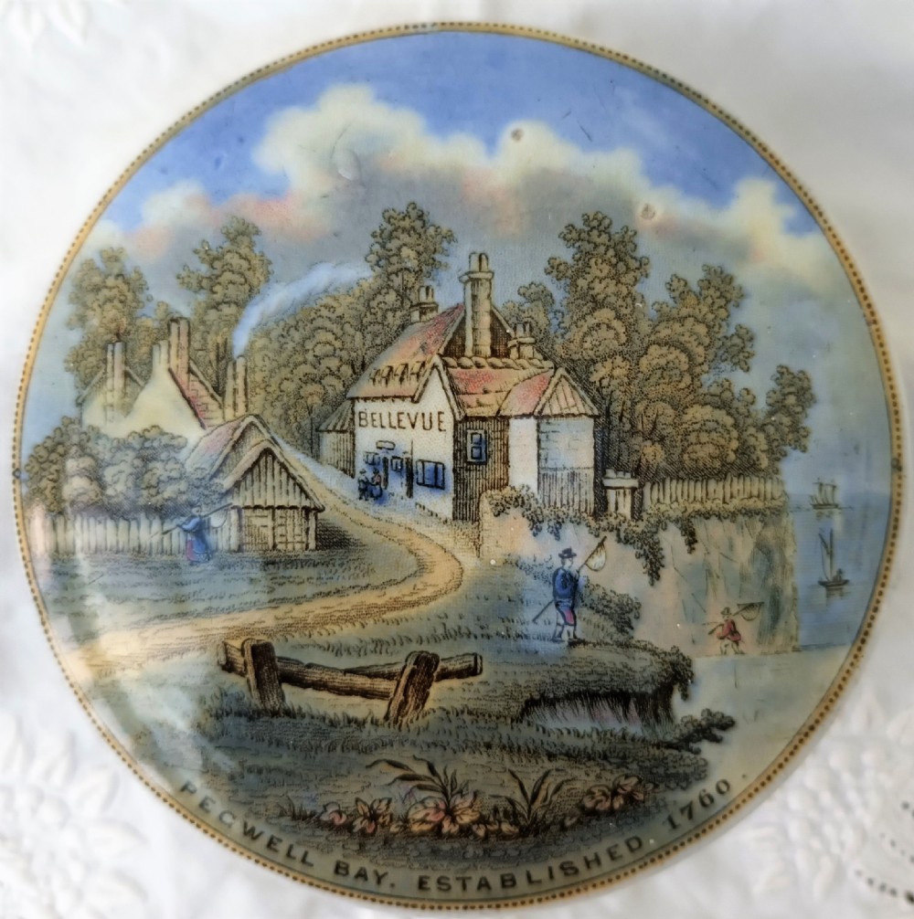 A round Victorian earthenware Prattware pot lid depicting a printed coastal scene of Pegwell Bay with the Bellevue inn and surrounding landscape.
