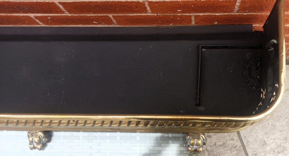 A Victorian pierced brass fireplace fender with central rope-twist moulding, pierced fretwork bands, and cast paw feet. View VIII