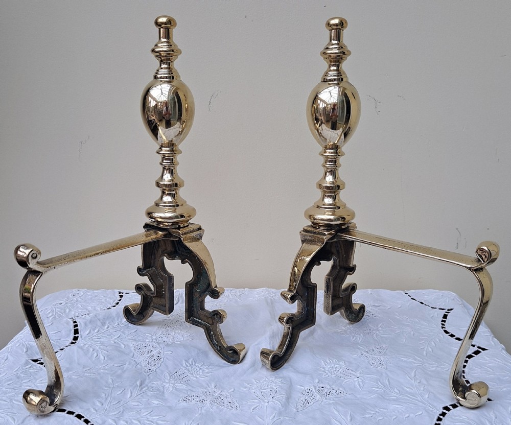Pair of polished Victorian cast brass andirons featuring urn finials, relief lion mask detail, and scrolling feet. View IV