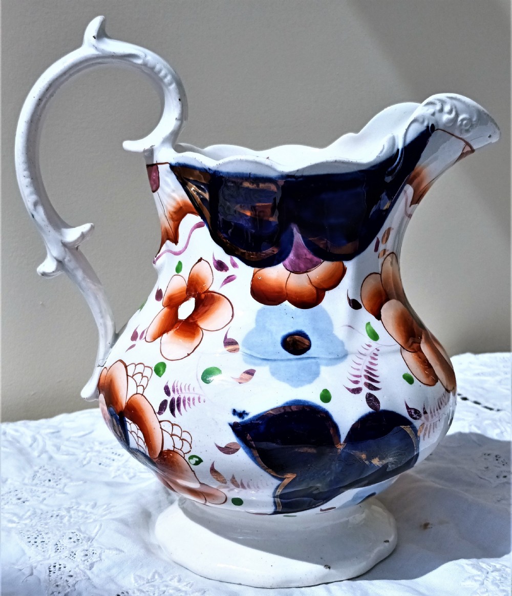 A Victorian Gaudy Welsh pottery jug featuring hand-painted cobalt blue and orange floral motifs with copper lustre accents and an ornate white handle. View III