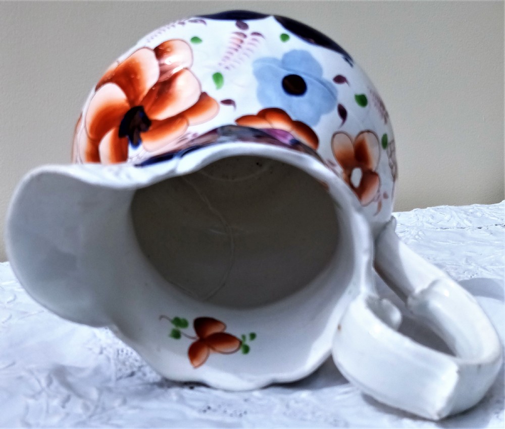 A Victorian Gaudy Welsh pottery jug featuring hand-painted cobalt blue and orange floral motifs with copper lustre accents and an ornate white handle. View V