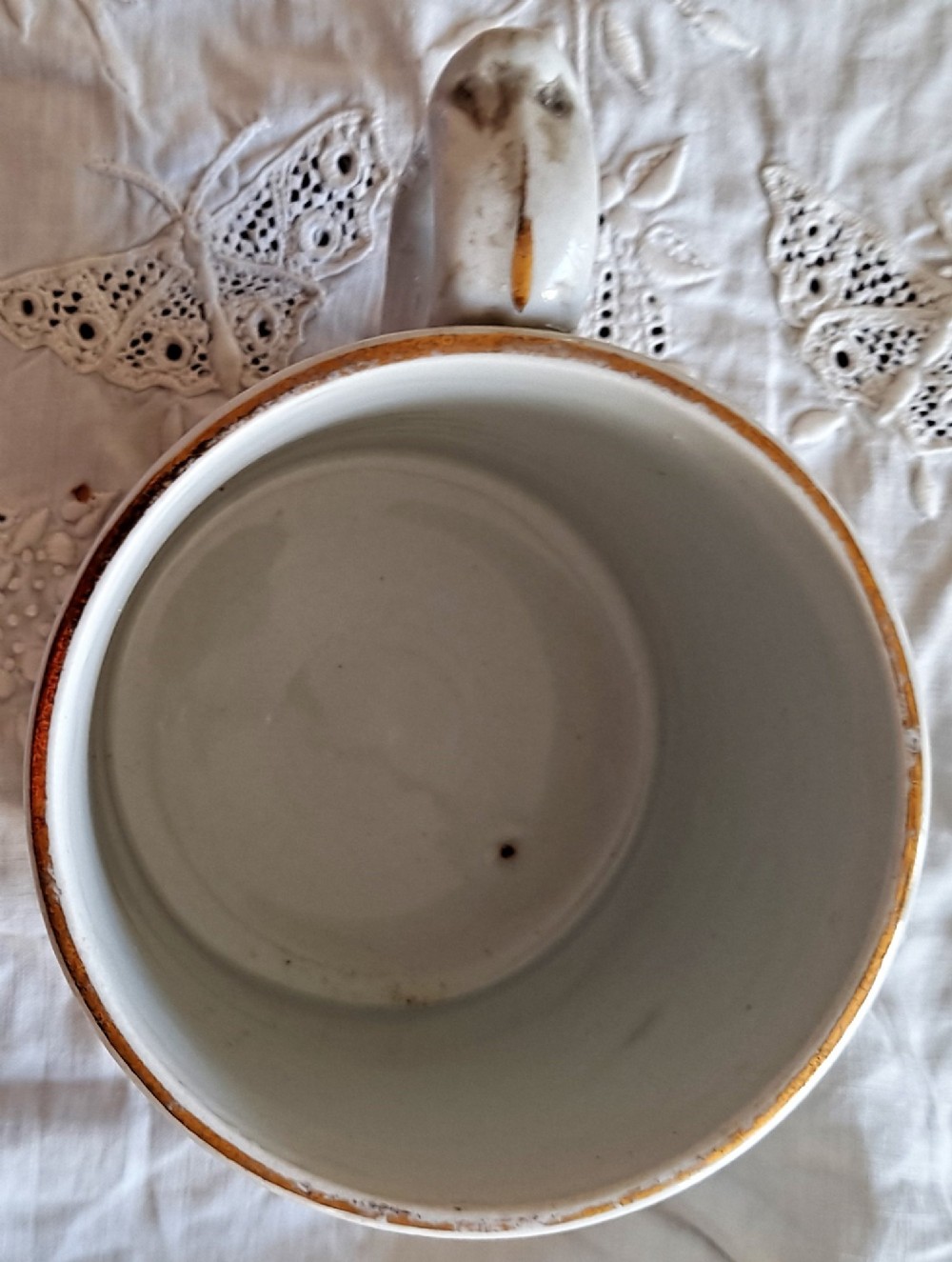 A white ceramic mug decorated with blue transfer-printed portraits of King Edward VII and Queen Alexandra alongside heraldic emblems. View V