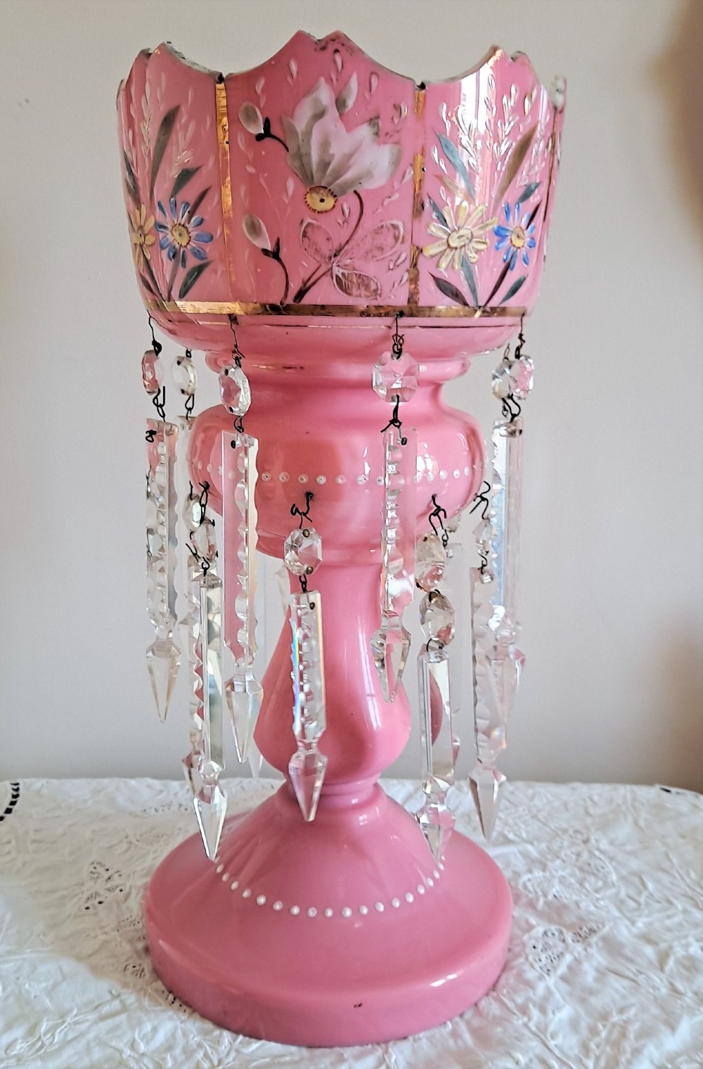 A Victorian pink glass mantel lustre featuring hand-painted floral enamel details, gilt trimming, a castellated top, and hanging clear cut-crystal prisms. View IV