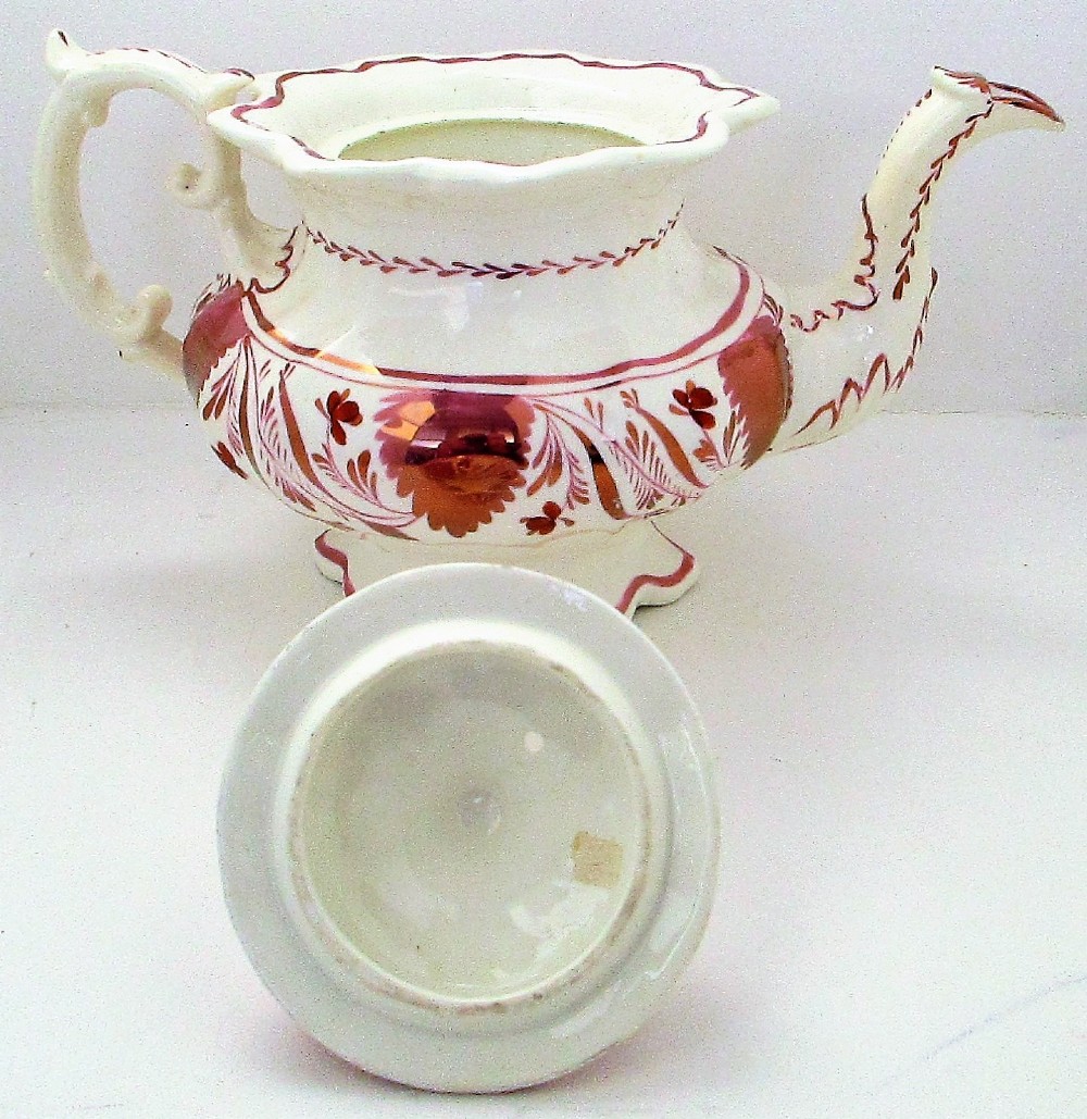 An antique white porcelain teapot decorated with pink iridescent metallic leaf motifs, a scalloped base, curved spout, and molded finial lid. View VIII